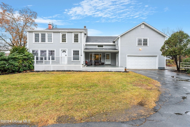 view of front of house with covered porch, a front yard, and a garage