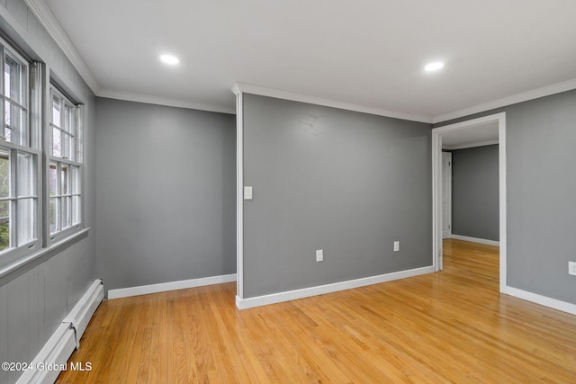 spare room featuring crown molding and light hardwood / wood-style floors