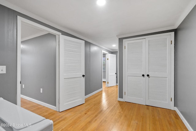 corridor featuring light wood-type flooring and crown molding