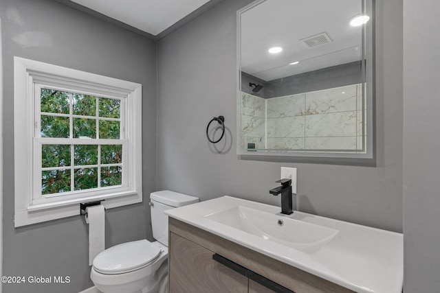 bathroom featuring vanity, toilet, and a shower