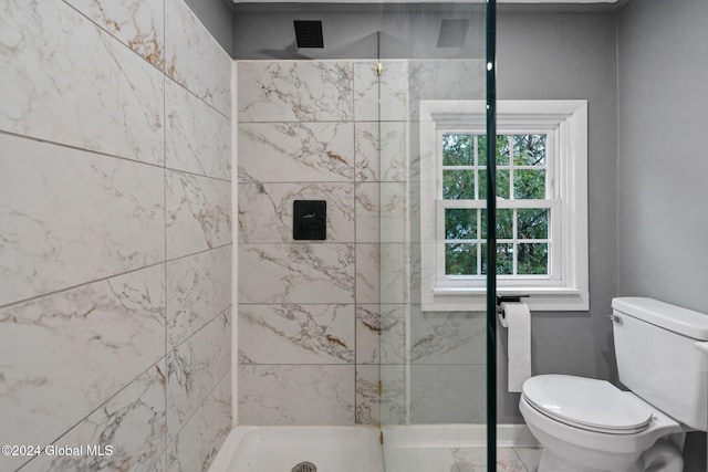 bathroom featuring toilet and tiled shower