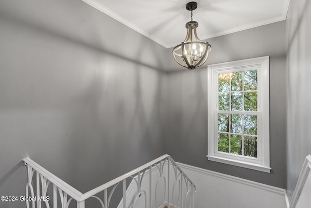 stairway with crown molding and an inviting chandelier