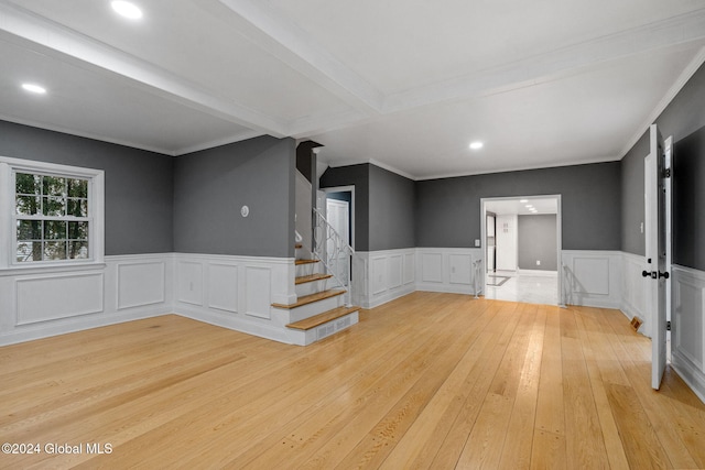 unfurnished room featuring beam ceiling, light hardwood / wood-style floors, and ornamental molding