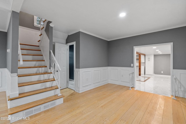 stairs featuring wood-type flooring and ornamental molding