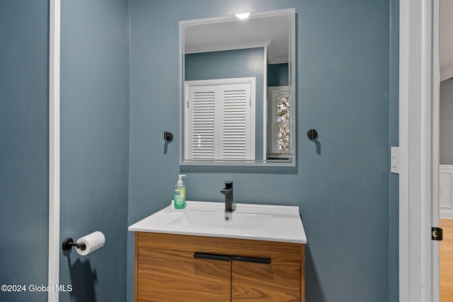 bathroom with vanity, ornamental molding, and hardwood / wood-style flooring