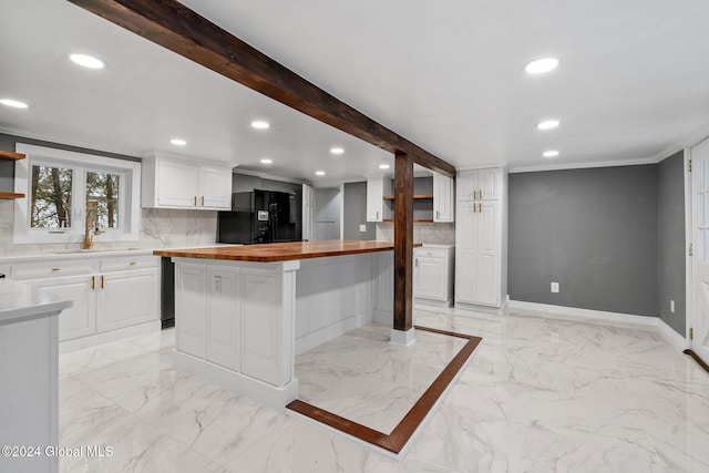 kitchen with white cabinets, wood counters, sink, and black refrigerator with ice dispenser