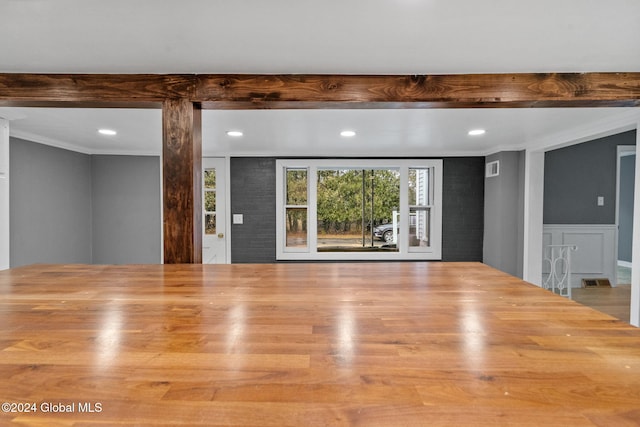 unfurnished living room with light hardwood / wood-style floors and crown molding