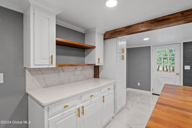 kitchen with white cabinets, tasteful backsplash, wood counters, and ornamental molding