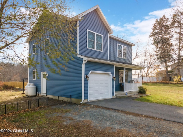 view of front of property with a porch, a garage, and a front lawn