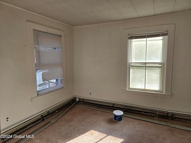 carpeted empty room with a baseboard radiator