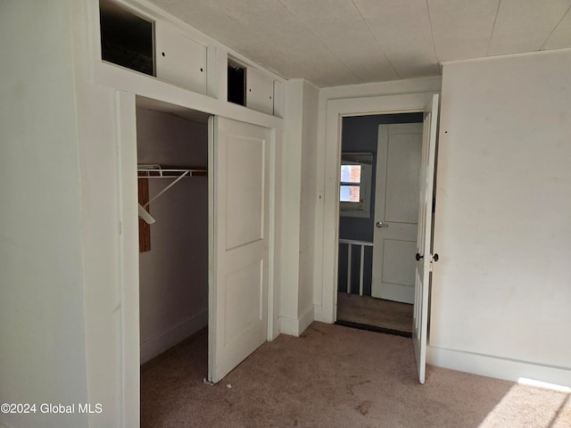 unfurnished bedroom featuring light carpet and a closet