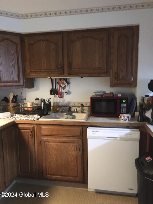 kitchen with dishwasher, dark brown cabinetry, and sink