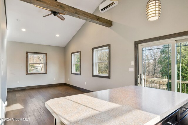 kitchen with beam ceiling, dark hardwood / wood-style flooring, a healthy amount of sunlight, and a wall mounted air conditioner