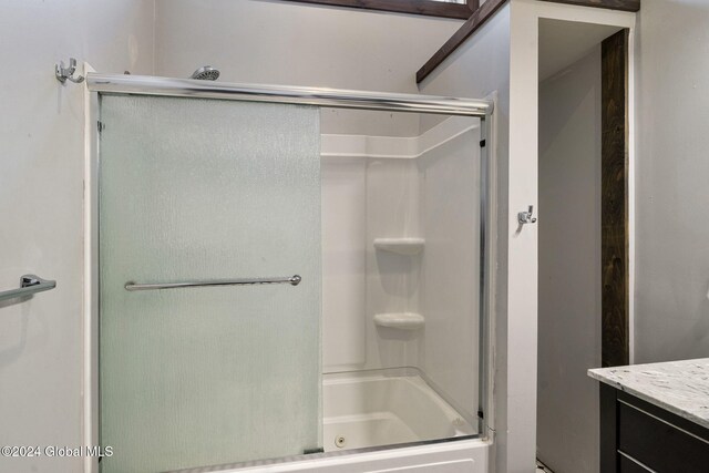 bathroom with vanity and enclosed tub / shower combo