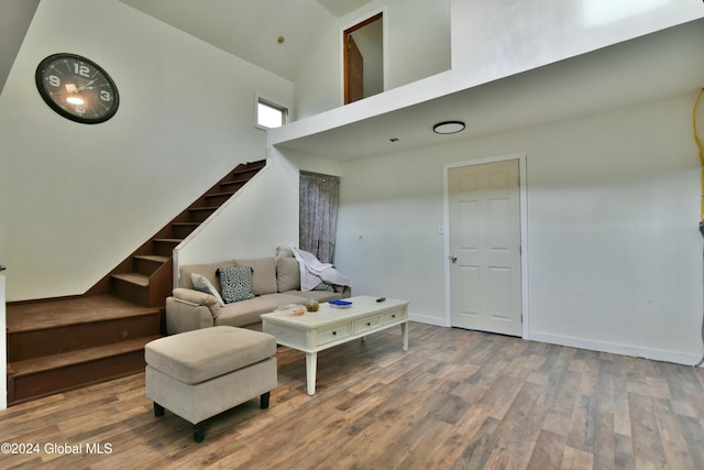 living room with hardwood / wood-style floors and high vaulted ceiling