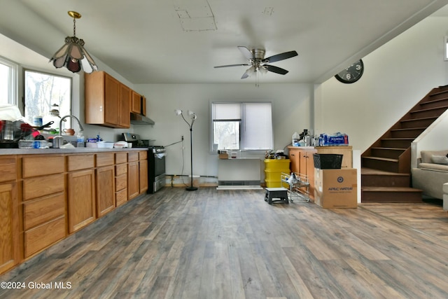 kitchen with stainless steel range, ceiling fan, sink, pendant lighting, and dark hardwood / wood-style floors