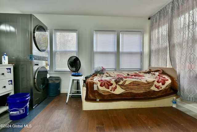 bedroom with dark wood-type flooring and stacked washer and clothes dryer