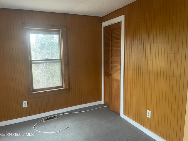 spare room with wood walls and carpet floors