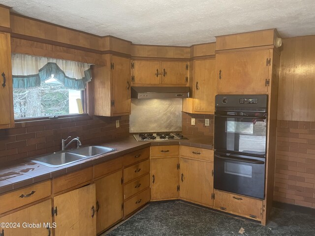 261 Fox Hill Rd, Edinburg, NY 12134 - kitchen featuring tile counters, a sink, under cabinet range hood, tasteful backsplash, and a textured ceiling