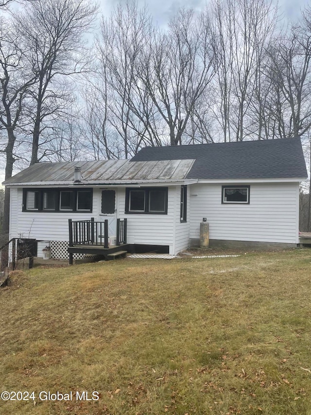 ranch-style house featuring a deck and a front lawn