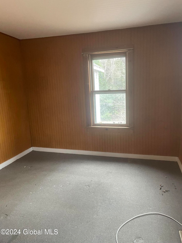 unfurnished room with wooden walls