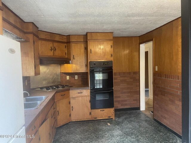 261 Fox Hill Rd, Edinburg, NY 12134 - kitchen with a sink, gas cooktop, freestanding refrigerator, under cabinet range hood, and wood walls