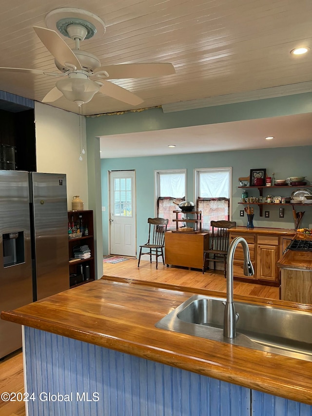 kitchen featuring stainless steel refrigerator with ice dispenser, light wood-type flooring, plenty of natural light, and sink