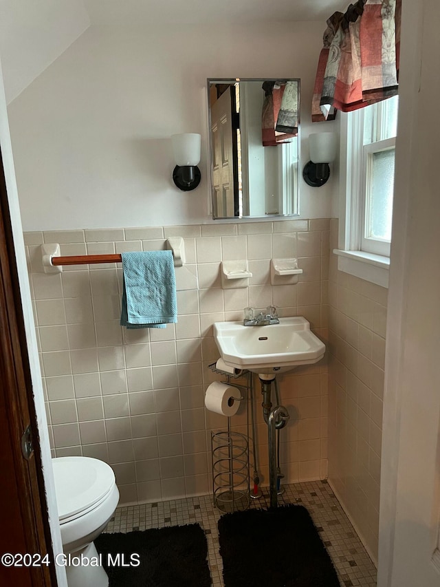 bathroom featuring tile patterned floors, toilet, lofted ceiling, and tile walls