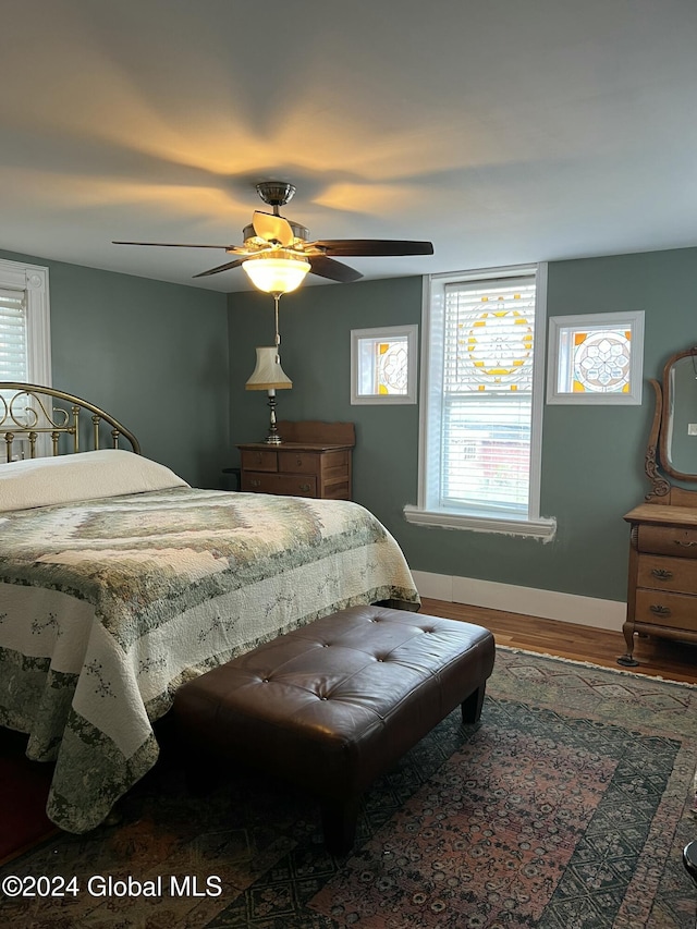 21 Willett St, Fort Plain, NY 13339 - bedroom featuring wood finished floors, multiple windows, baseboards, and ceiling fan