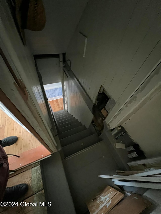 staircase featuring wooden walls