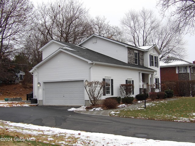 snow covered property with a garage