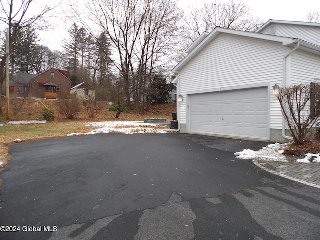 view of snow covered exterior with a garage