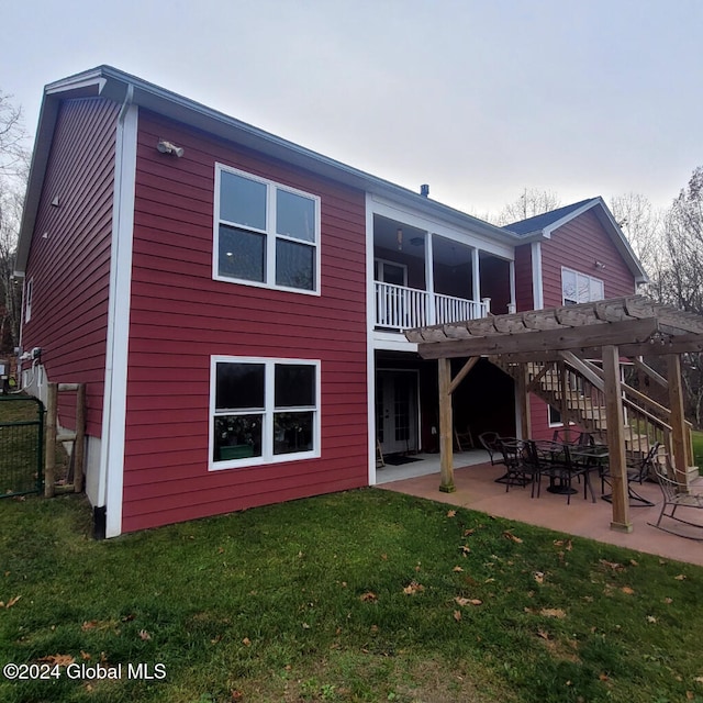 rear view of property with a pergola, a yard, a balcony, and a patio