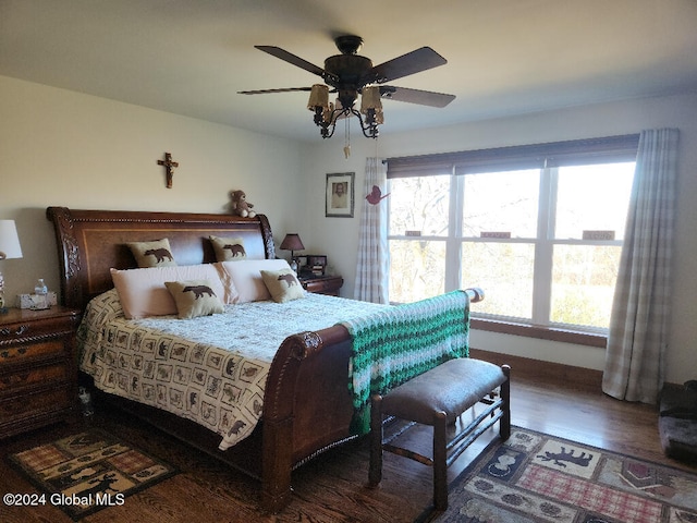 bedroom with multiple windows, ceiling fan, and dark hardwood / wood-style flooring