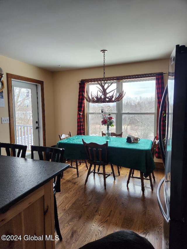 dining space with a chandelier, a wealth of natural light, and dark wood-type flooring