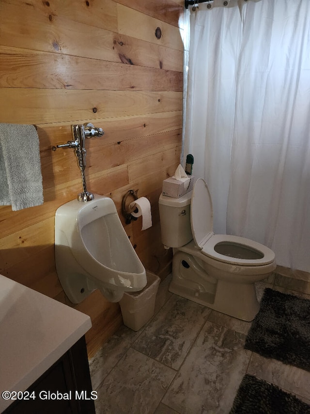 bathroom with wooden walls, vanity, and toilet