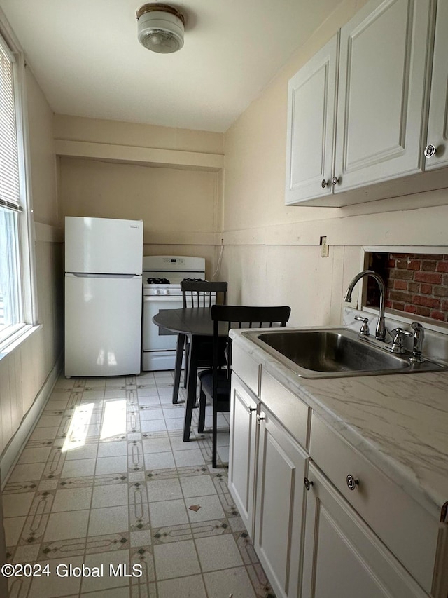 kitchen with sink, white cabinets, and white appliances