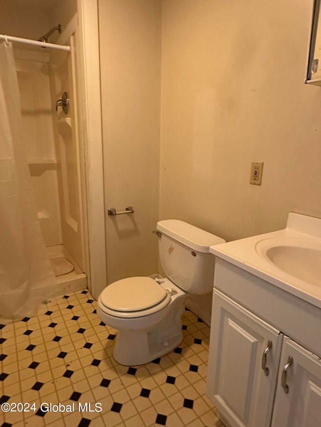 bathroom with a shower with shower curtain, vanity, and toilet