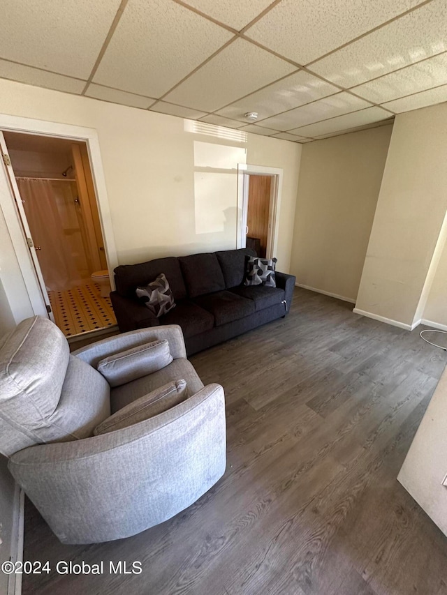 living room featuring a paneled ceiling and wood-type flooring