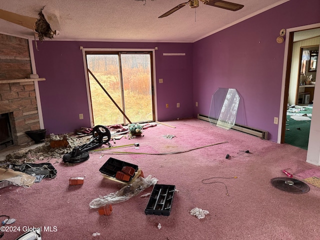 unfurnished bedroom with ceiling fan, a stone fireplace, crown molding, a textured ceiling, and carpet