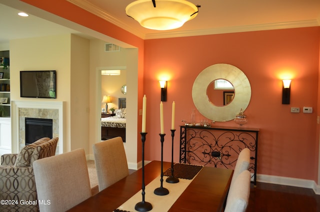 dining space with ornamental molding, dark wood-type flooring, and a tile fireplace