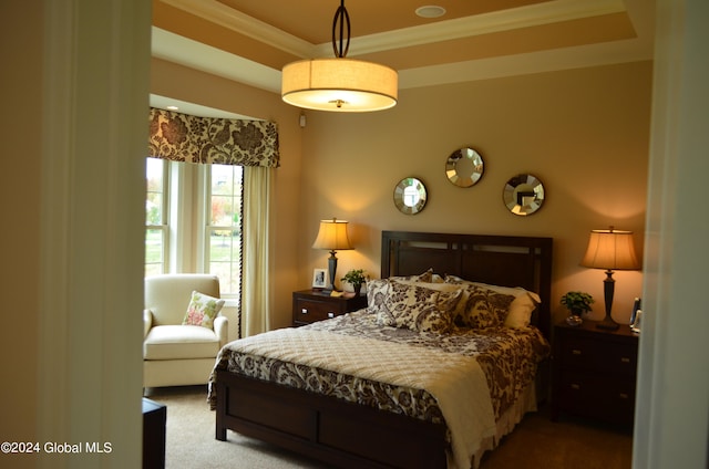 carpeted bedroom featuring a tray ceiling and ornamental molding