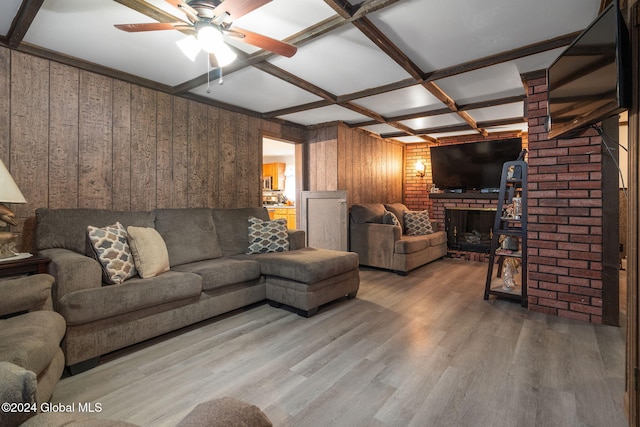 living room with wood walls, coffered ceiling, hardwood / wood-style flooring, a fireplace, and beamed ceiling