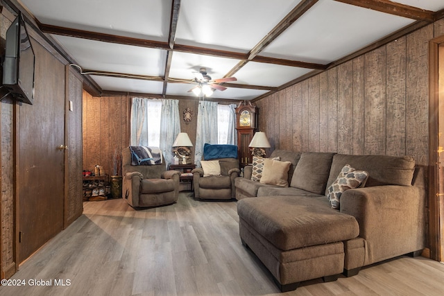 living room with wood walls, coffered ceiling, ceiling fan, beamed ceiling, and light hardwood / wood-style floors