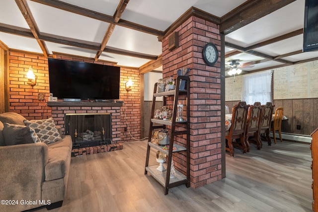 living room featuring coffered ceiling, a brick fireplace, hardwood / wood-style flooring, ceiling fan, and beam ceiling