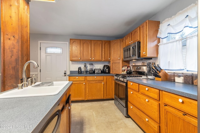 kitchen featuring stainless steel appliances, tasteful backsplash, and sink