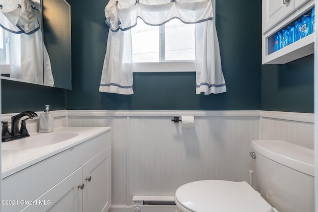 bathroom with vanity, toilet, and baseboard heating