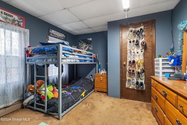 bedroom featuring light colored carpet and a drop ceiling