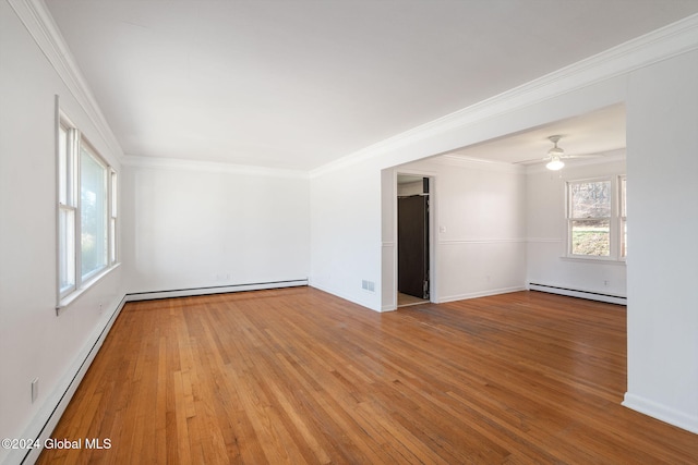 spare room with light hardwood / wood-style flooring, baseboard heating, ornamental molding, and ceiling fan