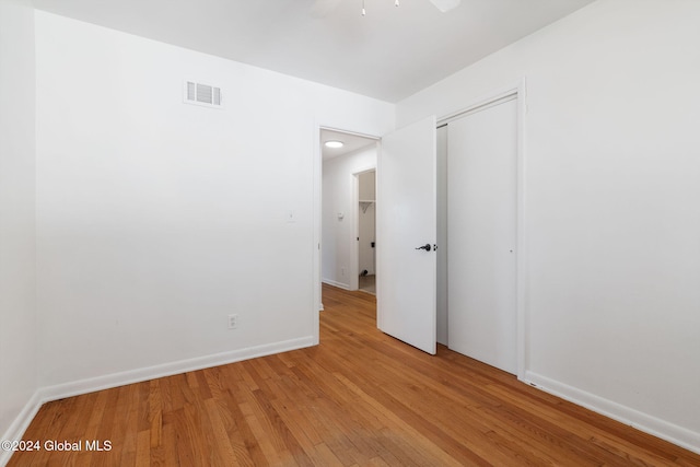 unfurnished bedroom with ceiling fan, a closet, and light hardwood / wood-style floors